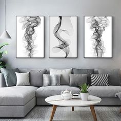 three black and white paintings in a living room