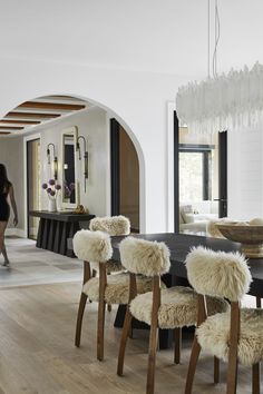 a dining room table with chairs and a chandelier hanging from the ceiling