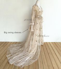 a white dress with gold sequins on it and the words big swing sleeves