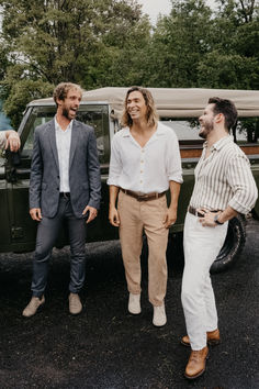 three men standing next to each other in front of a truck