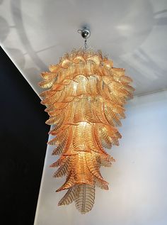 a chandelier hanging from the ceiling made out of gold leafy glass pieces