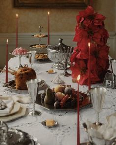 the table is set with candles, plates and desserts for two people to eat