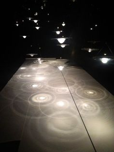 a long table with lights on it in the middle of a dark room at night