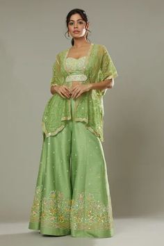 Green apple candy raw silk sharara cum palazzo, hand embroidered with cutdana and colorful sequins in floral pattern. Comes with embroidered padded bustier, hand embroidered bohemian kaftan and belt.
Component: 4
Pattern: Hand Embroidered
Type Of Work: Floral Appliques, Sequins Cutdana
Neckline: Sweetheart
Sleeve Type: Batwing Sleeves
Fabric: Raw Silk, Silk Organza
Color: Green
Other Details: 
Floral patters
Adjustable bustier straps
Back smocked bustier
Scalloped hem kaftan
Approximate product Green Apple Candy, Silk Sharara, Apple Candy, South Indian Blouse Designs, Blouse Designs Indian, Palazzo Pant, Palazzo Set, Indian Blouse, Gowns For Girls