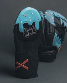 a pair of black and blue baseball gloves with doughnuts on them