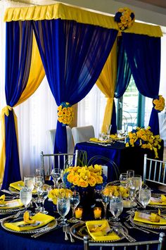 a table set with yellow and blue decorations