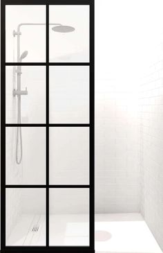 a white tiled bathroom with black framed glass shower doors and floor to ceiling windows that look out onto the outside