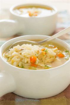 two white bowls filled with chicken and rice soup