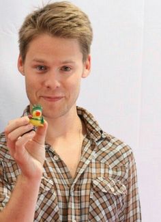 a man is holding a piece of food in one hand and looking at the camera