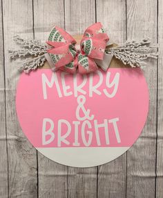 a merry and bright sign hanging on the side of a wooden wall with a bow