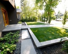 an outdoor area with grass and landscaping in the foreground, surrounded by trees and bushes