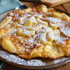 an apple pie on a plate with powdered sugar