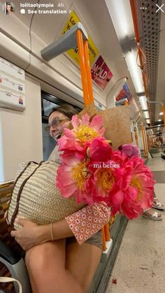 a woman is sitting on the subway with flowers in her hair and wearing a hat