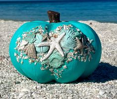 a blue pumpkin decorated with sea shells and starfish