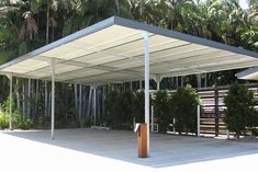 an empty covered parking lot with trees in the background