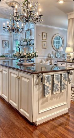 a kitchen island with towels hanging from it's hooks and lights on the ceiling