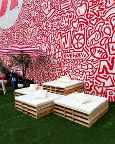 two wooden benches sitting in front of a red and white wall