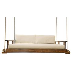 a white couch sitting on top of a wooden frame with two swings attached to it