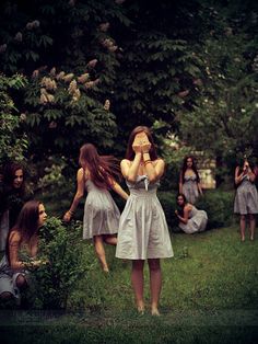 a group of young women standing on top of a lush green field