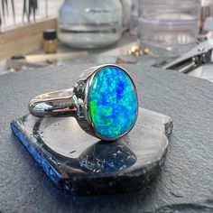 Large statement blue green opal ring set in solid 14k gold.  Insanely bright play of color in this stunning Coober Pedy Australian opal! This is a shell opal doublet stone. A clam or other mollusk shell that was opalized millions of years ago. Expertly cut and made into a doublet by a skilled Australian cutter.  Re-cut in my shop to a free-form oval shape. Shell doublets are thicker and usually domed compared to normal opal doublets (see pictures) Large 5.57 carat stone. over 4 grams solid 14k y Unique Oval Opal Birthstone Ring, Hallmarked Oval Opal Ring, Green Opal Cabochon Ring, Polished Opal Oval Cabochon Ring, Polished Opal Ring In Oval Cabochon Shape, Opal Oval Cabochon Ring With Polished Finish, Fine Jewelry Green Opal Ring, Blue Opal Round Ring, Green Opal Ring Gift