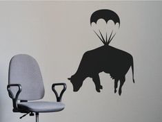 an office chair sitting in front of a wall with a cow on it's back