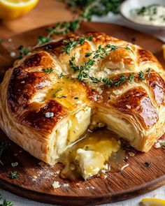 a cheesy bread dish on a cutting board with lemons in the background