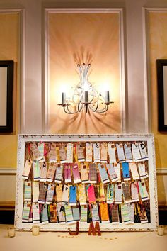 a bulletin board covered in lots of notes next to a wall with a chandelier