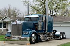 a blue semi truck parked in front of a house