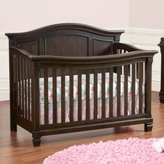 a baby crib in a room with pink rugs