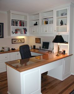 a home office with white cabinets and wooden floors