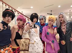 group of women dressed in costumes standing next to each other with cell phones on their heads