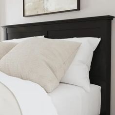 a black headboard with white pillows in a bedroom