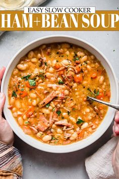 two hands holding a bowl of slow cooker ham and bean soup with text overlay