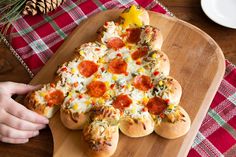 a pizza shaped like a christmas tree on a wooden platter