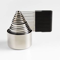 a stack of metal cups sitting next to each other on top of a white table