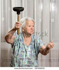 an old woman holding a broom over her head