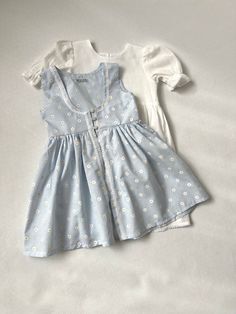 ✿ABOUT THIS DRESS ✓Our handmade set includes a white dress with front knot detail and a soft blue daisy flower-detailed toddler apron look.  ✓The white dress is also lined from the inside, providing extra comfort and durability. ✓The small daisy flower pattern on the apron adds cuteness to the overall look, making your little one look even more adorable.  ✿FABRIC INFORMATION ✓Natural cotton lining 100% under the skirt, cotton, terry cotton fabric. ✓Color of your item may vary slightly from what Light Blue Cotton Sundress For Spring, Cute Cotton Dresses For Day Out, White Cotton Sundress For Picnic, Casual Fitted Pinafore Dress For Spring, Light Blue Sundress For Spring Garden Party, Light Blue Sundress For Garden Party In Spring, Cute Cotton Sundress For Daywear, Cute Sundress For Spring Daywear, Cute Daisy Print Summer Dress