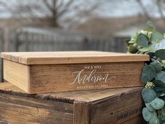 a wooden box sitting on top of a table next to a flower potted plant