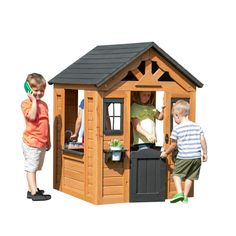 two children are playing in a wooden play house with the doors open and one child is talking on his cell phone