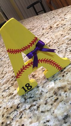 a baseball themed paper mache with a purple bow on it's head sitting on a counter top