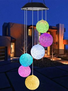 an outdoor light fixture with four balls hanging from it's sides and two lights on the