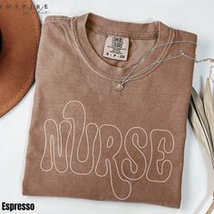 a brown shirt with the word nurse written on it next to a cowboy hat and other items