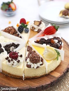 a cheesecake with fruit and chocolate toppings on a wooden platter