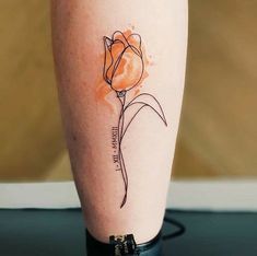 a tattoo on the leg of a woman with a single orange flower in it's center