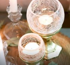 two candles sitting on top of a glass table