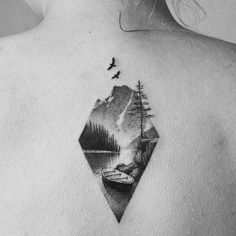 the back of a woman's shoulder with an image of mountains and trees on it