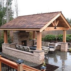 an outdoor living area with patio furniture and stone fireplace