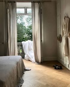 a bedroom with an open door leading to another room and a pair of shoes on the floor