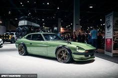 a green sports car on display at an auto show