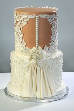 a wedding cake decorated with white flowers and lace